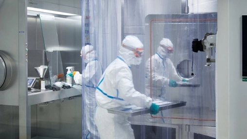 Pharmaceutical technicians working in a cleanroom drug development laboratory