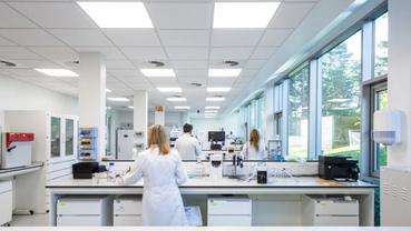 Modern drug research laboratory with researchers conducting experiments