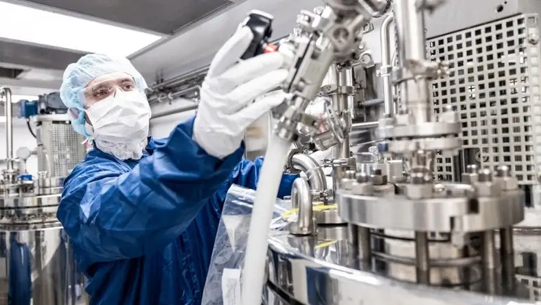 Technician inspecting pharmaceutical manufacturing equipment