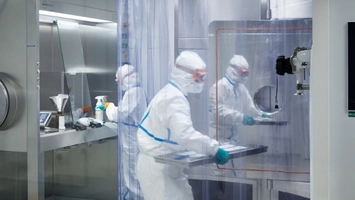 Pharmaceutical technicians working in a cleanroom drug development laboratory