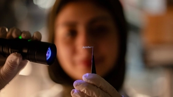 Cl ose-up of a tiny implant device inspected during drug delivery research