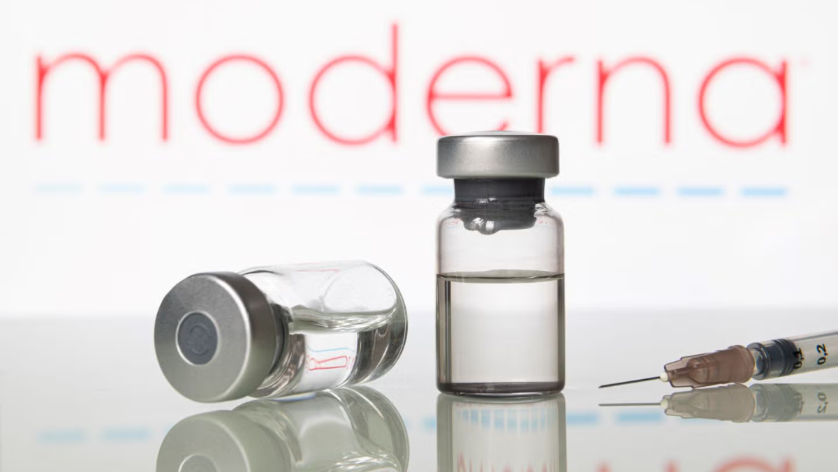 Vaccine vials and syringe displayed in front of the Moderna logo.