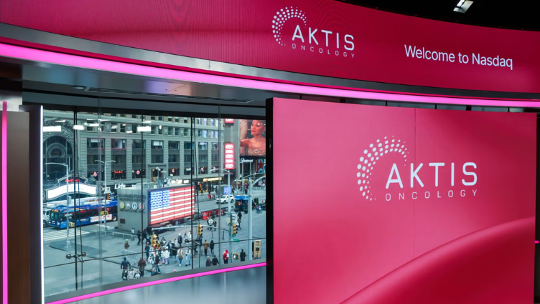 Aktis Oncology logo on digital screens inside the Nasdaq MarketSite