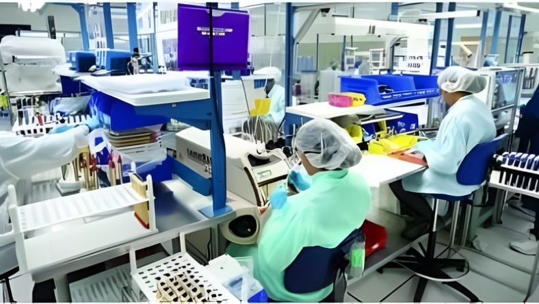 Technicians working on drug delivery device assembly in a pharmaceutical facility