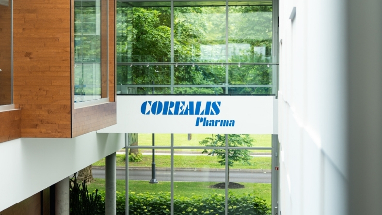 Corealis Pharma logo displayed inside modern glass office building